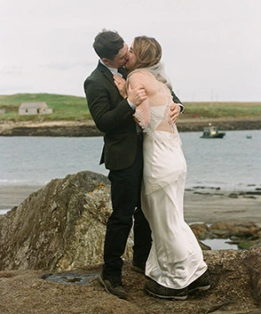 Bride an dgroom are kissing each other on their Isle of Skye beach elopement. Photo captured on 35mm film