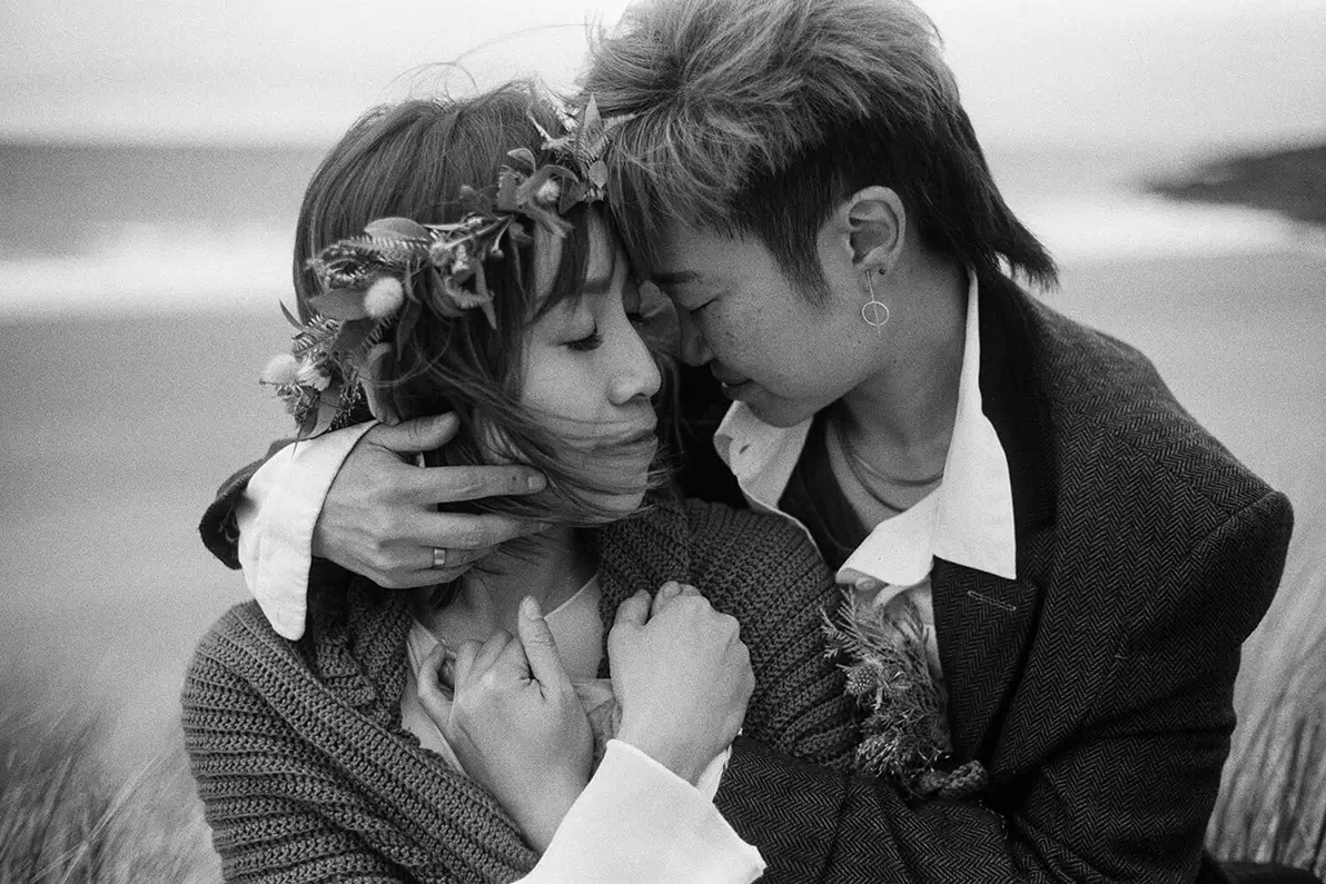 LMBTQ couple coudle at the Scottish beach side on their elopement day